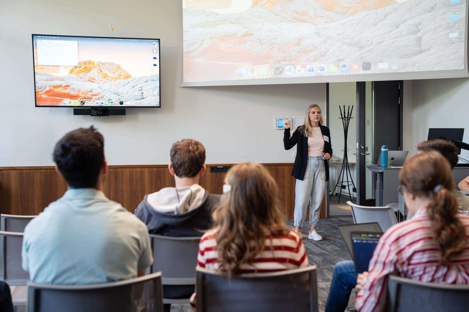 Carmen Kivisild presenting at the front of a classroom at Estonian Business School while YESS 2026 participants watch from their seats.