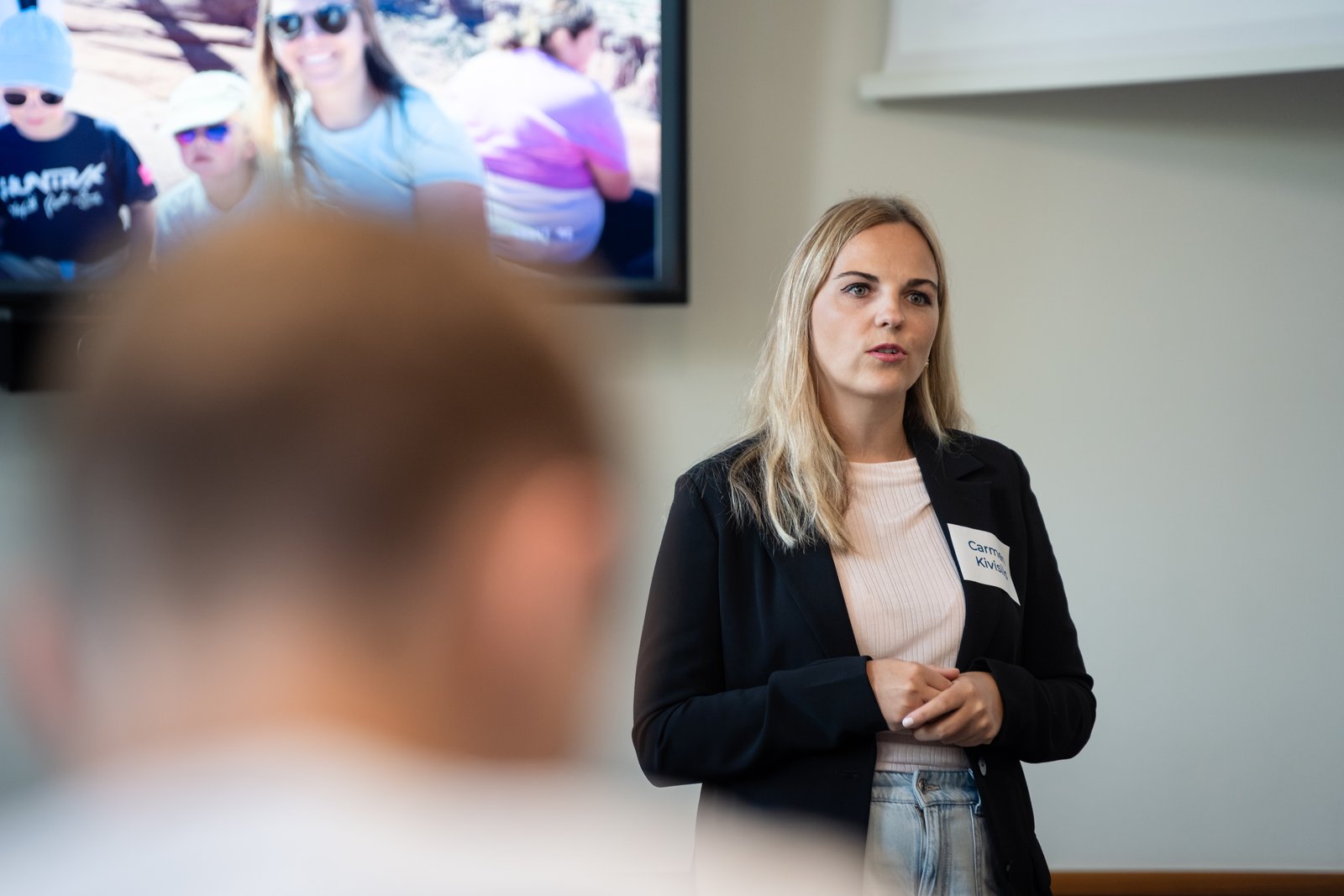 Carmen Kivisild talking to the room, with a participant in the foreground.
