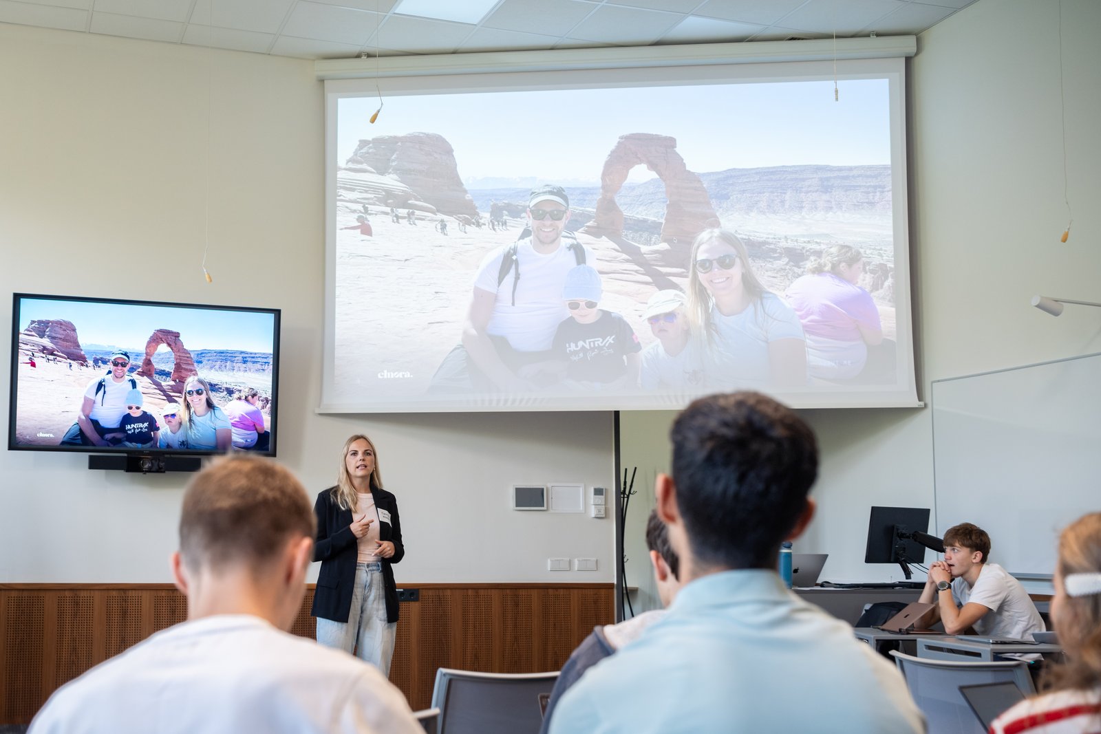 Carmen Kivisild presenting in front of a projected photo from Utah.