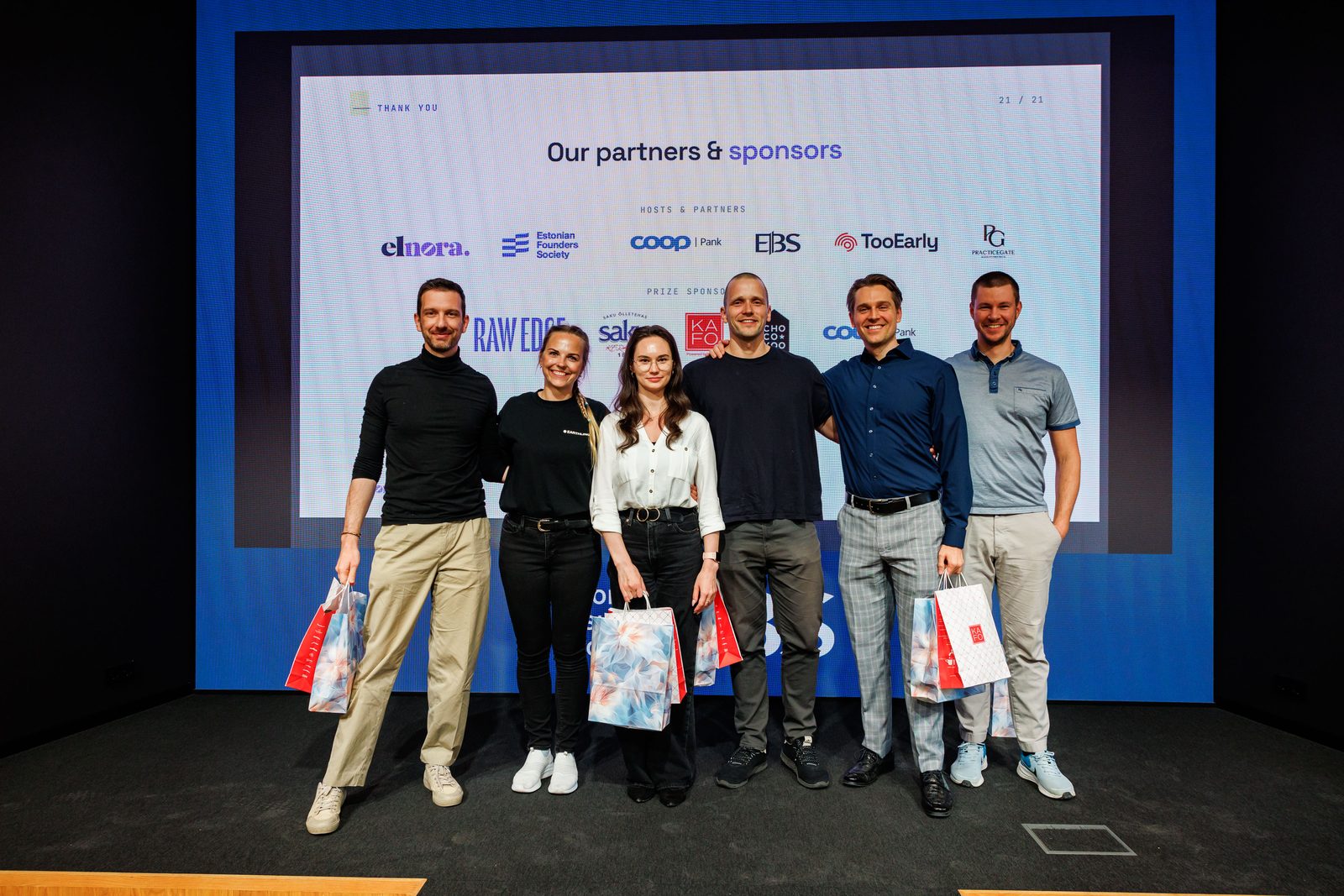 Build Day organisers and winners on stage with their prize bags, in front of the partners slide.