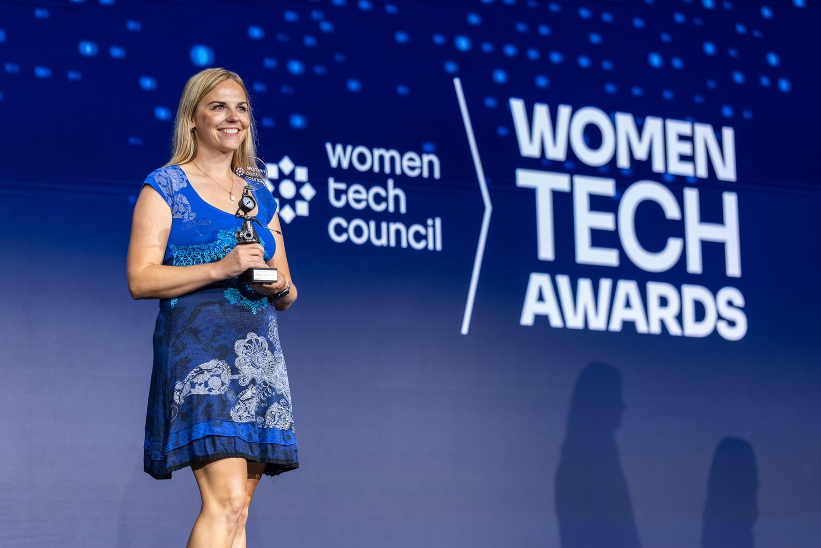 Carmen Kivisild on stage at the 2026 Women Tech Awards, holding her trophy in front of the Women Tech Council backdrop.
